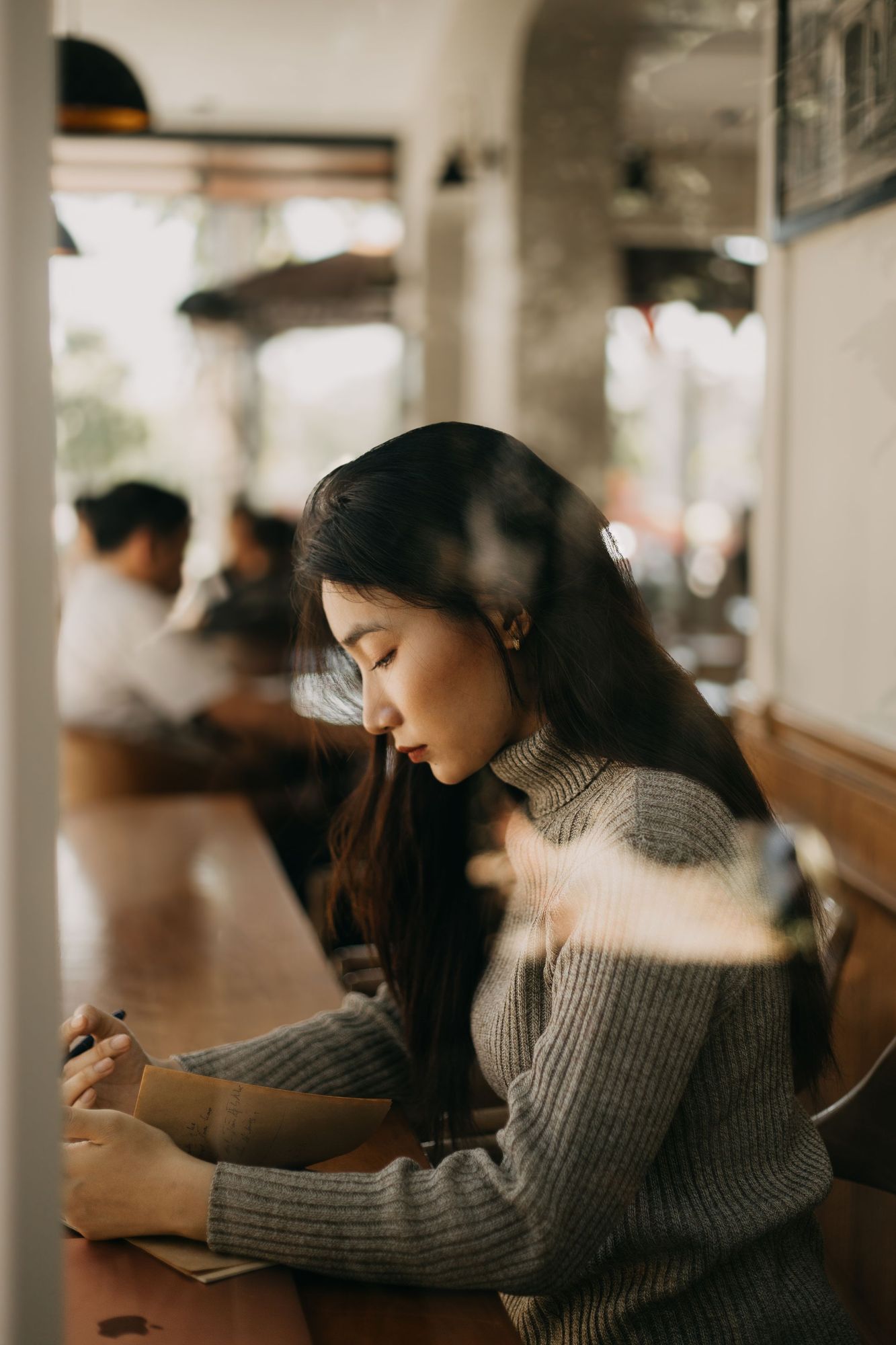 A woman writing in a notebook at a café table