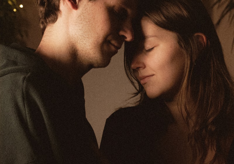 Two people resting their heads together