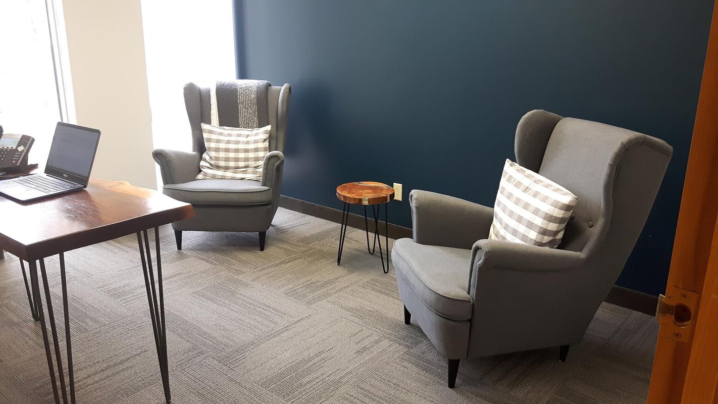 A therapy room at the Burlington office, with two armchairs and a small desk