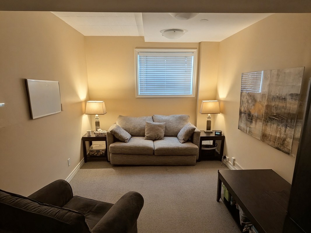 A therapy room at the St. Catharines office, with a sofa, armchairs and table lamps