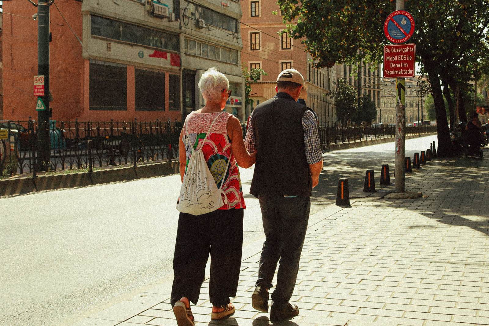 An older couple walking together down a city street
