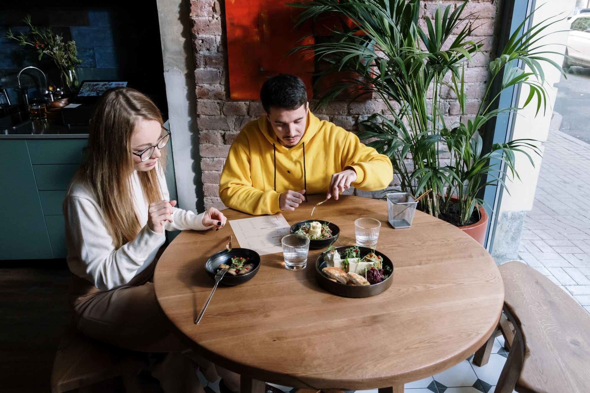 Two friends sharing a meal at a café table