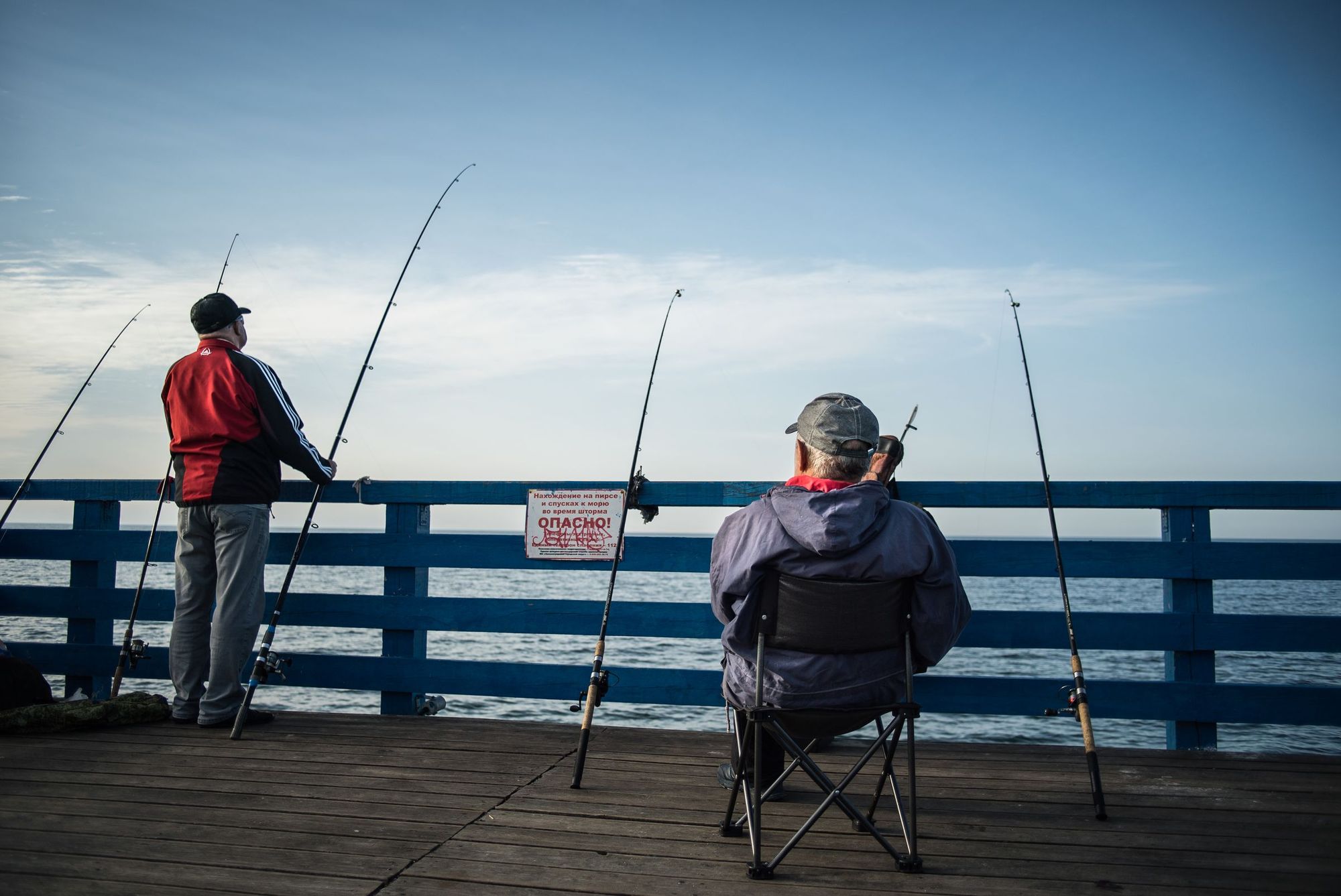 Two men fishing off a pier