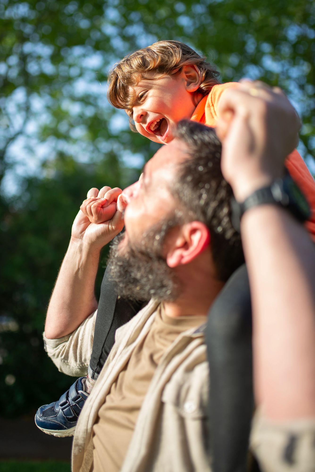 A father carrying his child on his shoulders outdoors