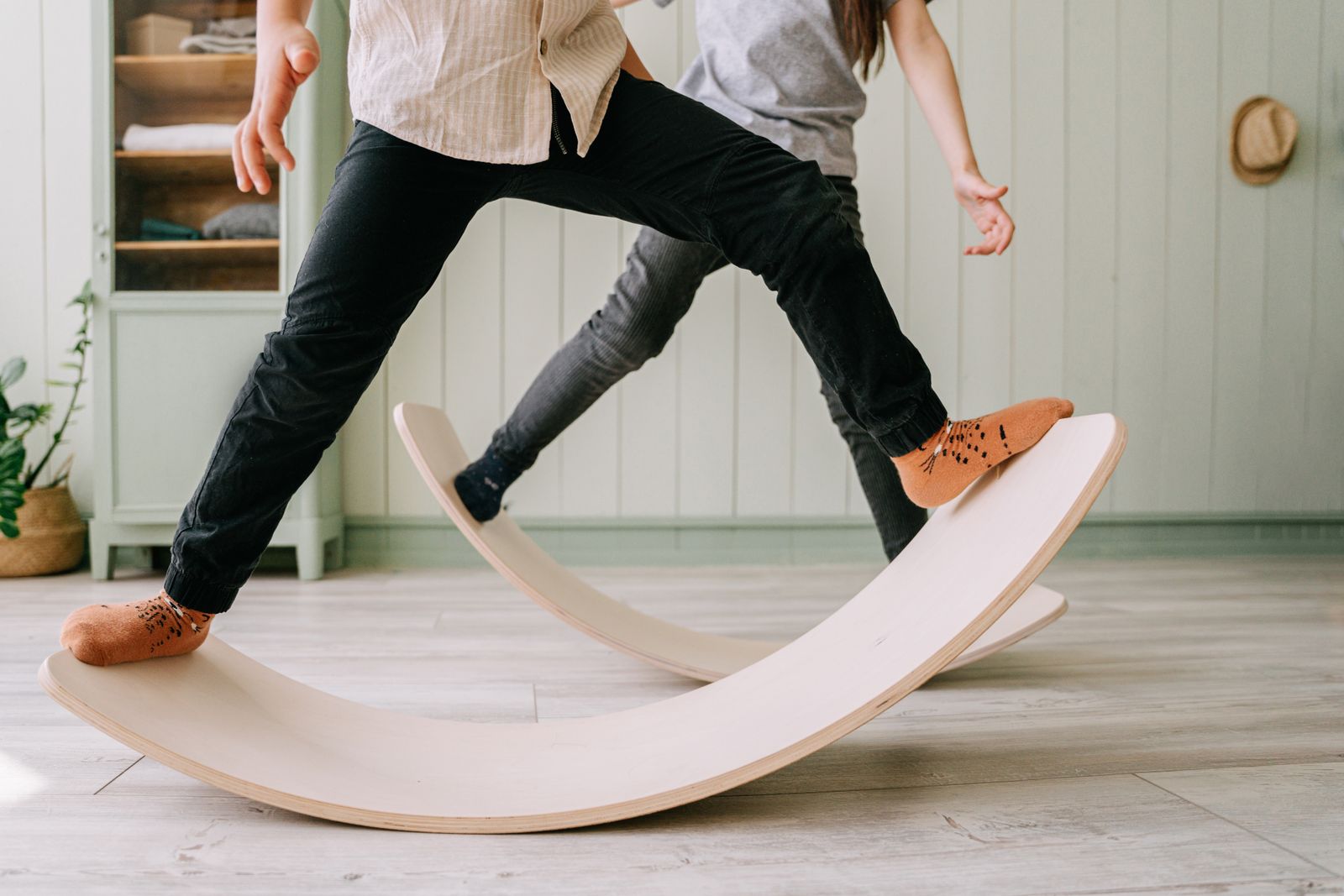 Two children rocking on curved wooden balance boards